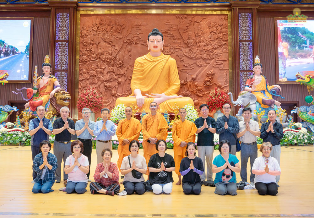 The monks and the group took souvenir photos at the Great Lecture Hall, the world's largest on-mountain lecture hall