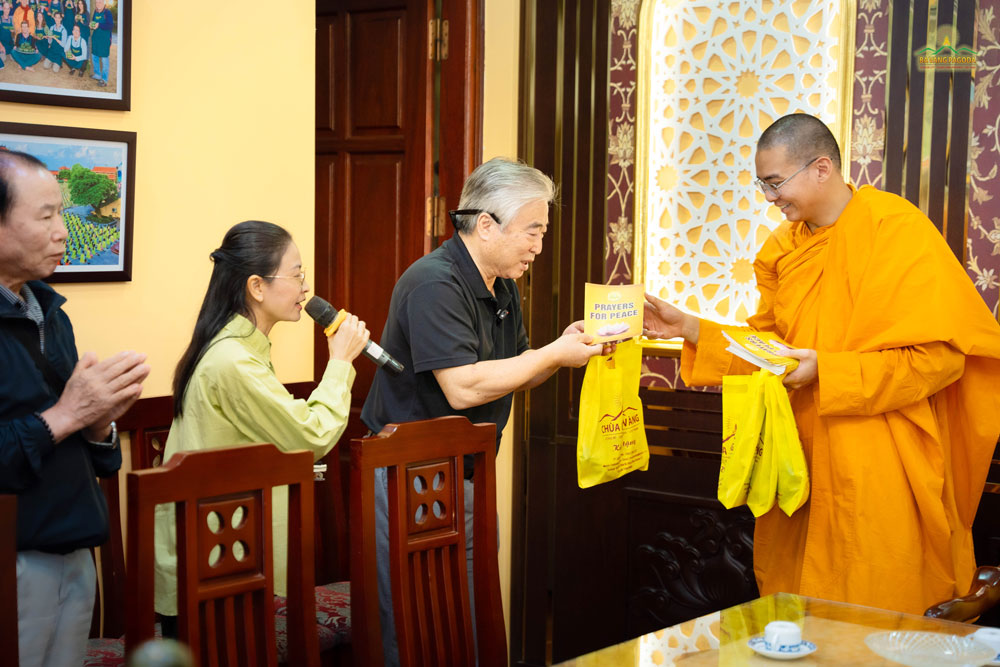 The group happily received valuable gifts from the pagoda, which were sutras and verses from the Buddha's teachings for peace in life