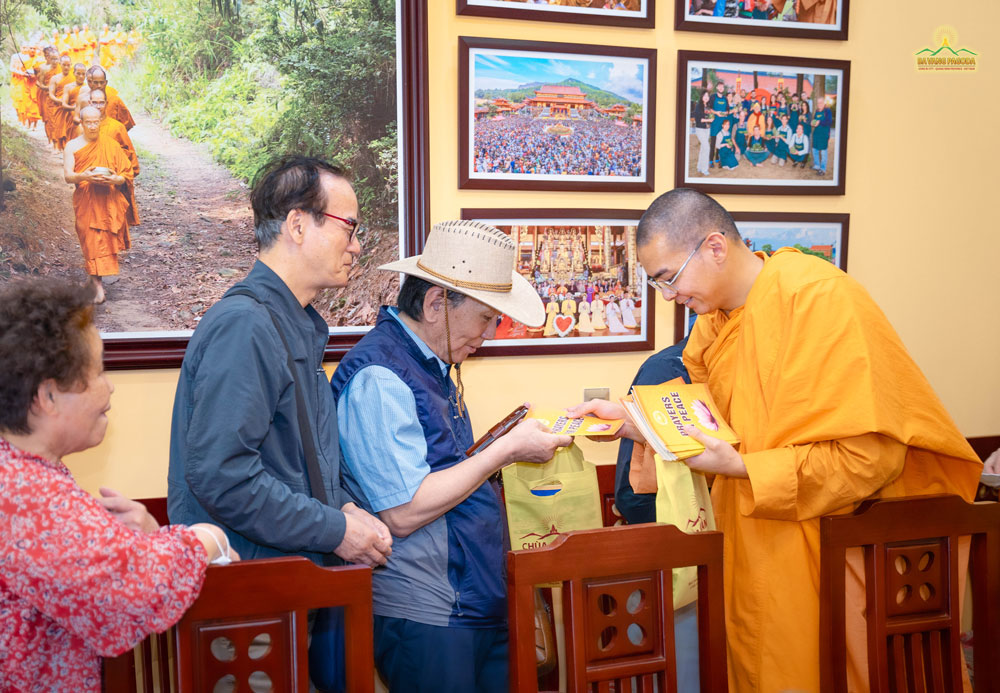 The group happily received valuable gifts from the pagoda, which were sutras and verses from the Buddha's teachings for peace in life