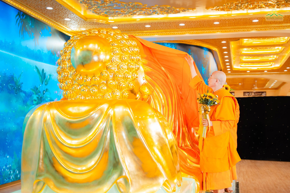 Thay and the monks reverently offered a noble saffron robe to the golden statue of the Buddha