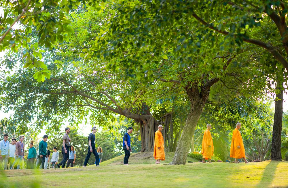 Foreign retreatants practice walking meditation under the instruction of monks at Ba Vang Pagoda.