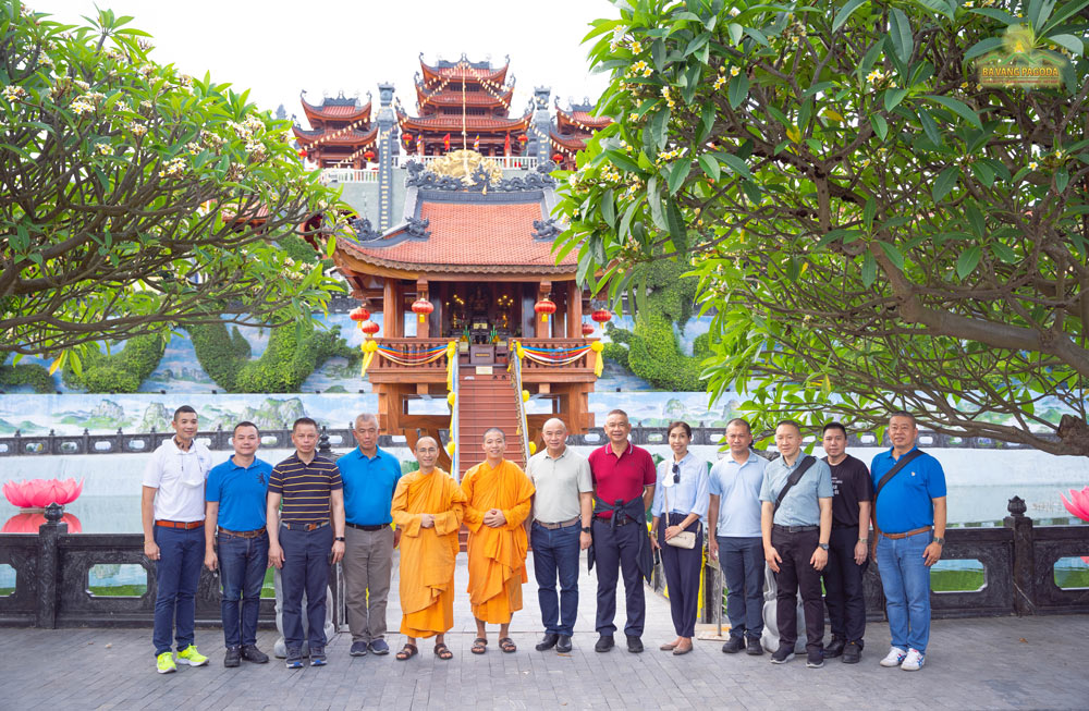 The monks and the delegation took a souvenir photo in front of the One-Pillar Pagoda at Ba Vang Pagoda.