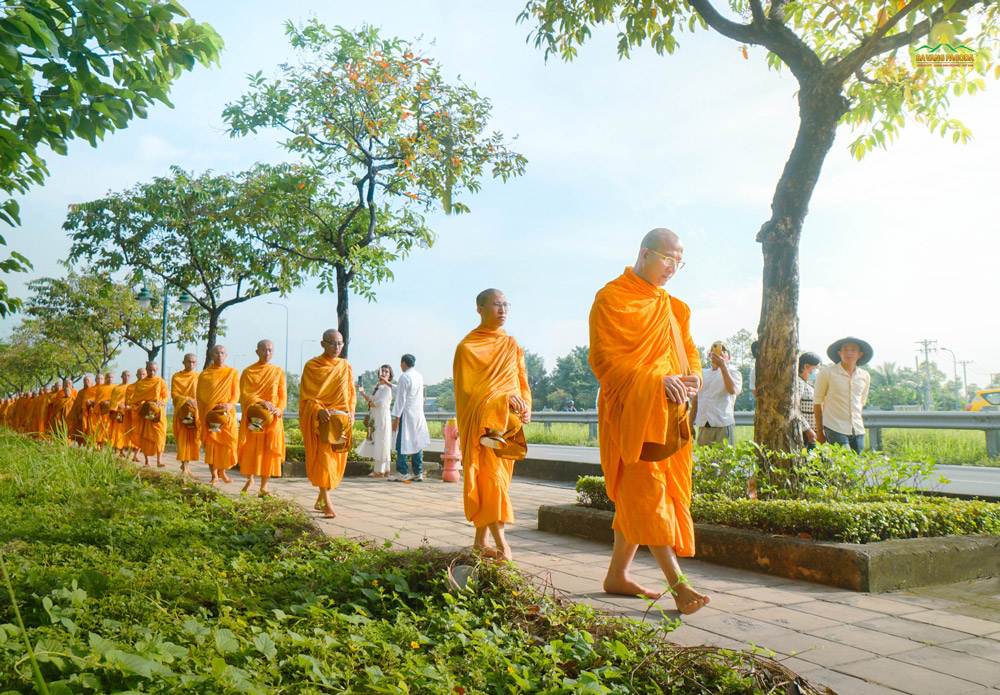 The image of monks holding their alms bowls with bare feet on the path grounds partly evoked the image of the Sangha walking for alms in the Buddhas time.