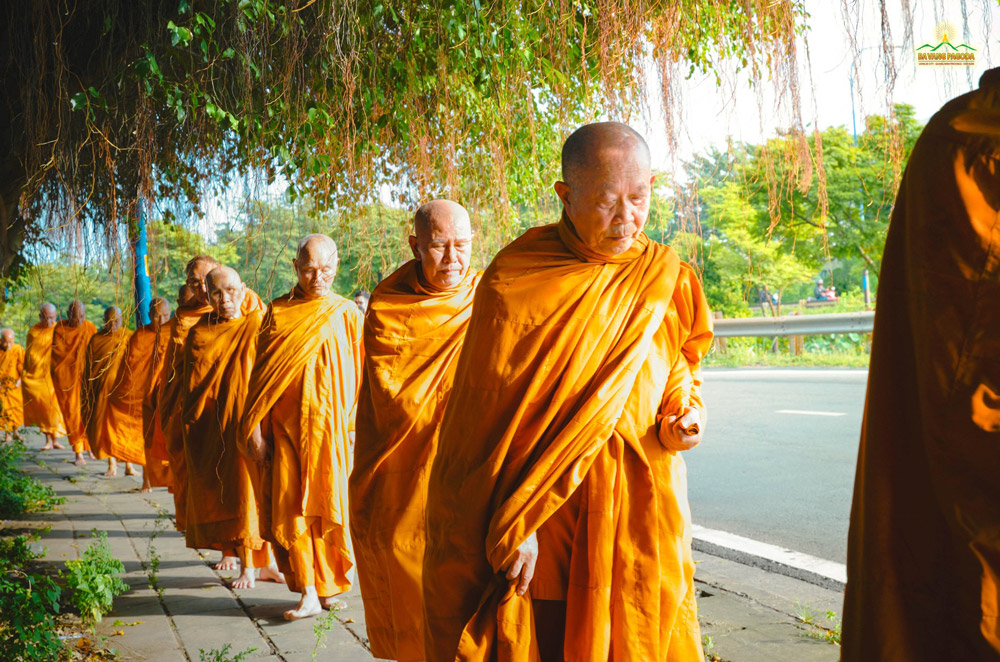 The venerable monks walked calmly along the street during the alms-giving ceremony.