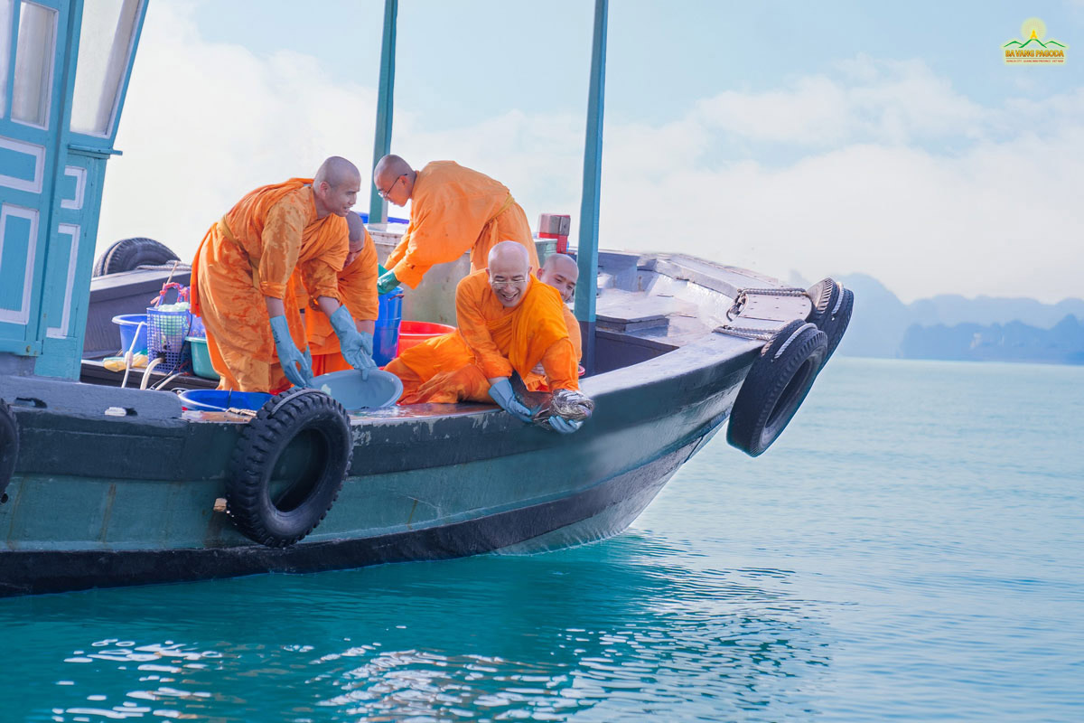 The merit from life release can give us the blessing of longevity. (Photo: Thay Thich Truc Thai Minh and Monks of Ba Vang Pagoda releasing a fish at Halong Bay.)