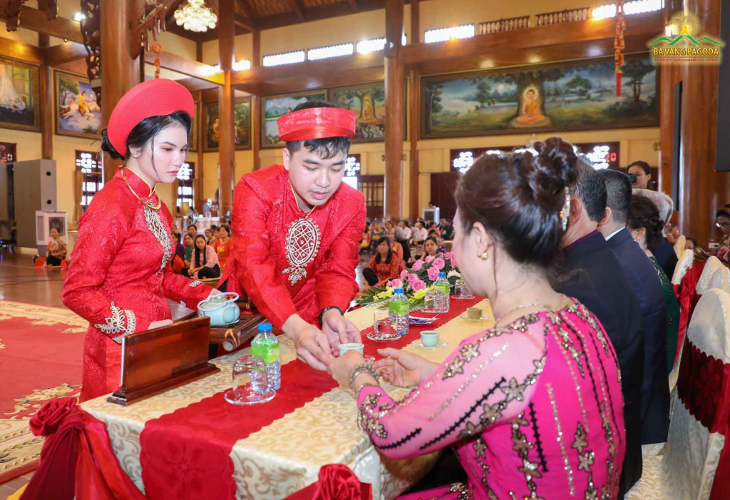 A couple offering tea to parents at Hang Thuan ceremony at Ba Vang Pagoda.