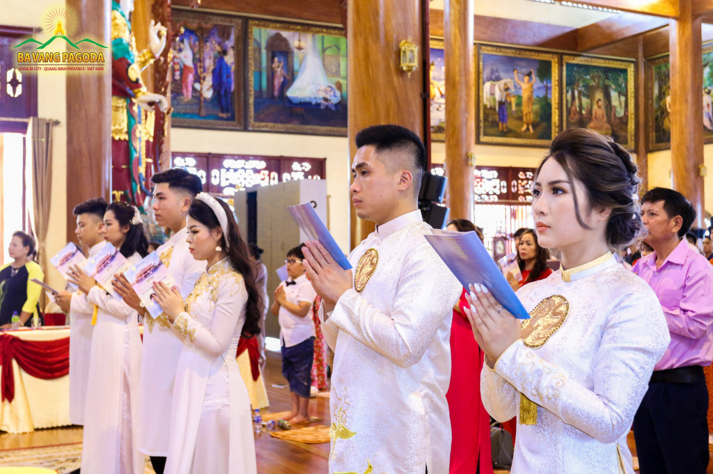Couples reverently join their hands towards the Three Jewels