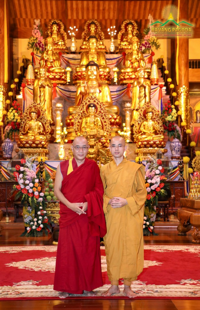 Rinpoche and Venerable taking a photo in front of the Altar.