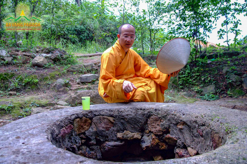 Venerable Thich Truc Thai Minh—a disciple of Truc Lam Zen sect—sitting next to the archaic Godly Well.