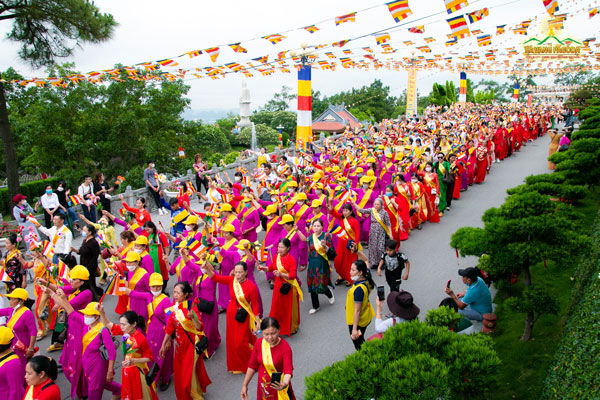 A group of paraders, dressed in colorful ao dais, walked in an orderly formation.