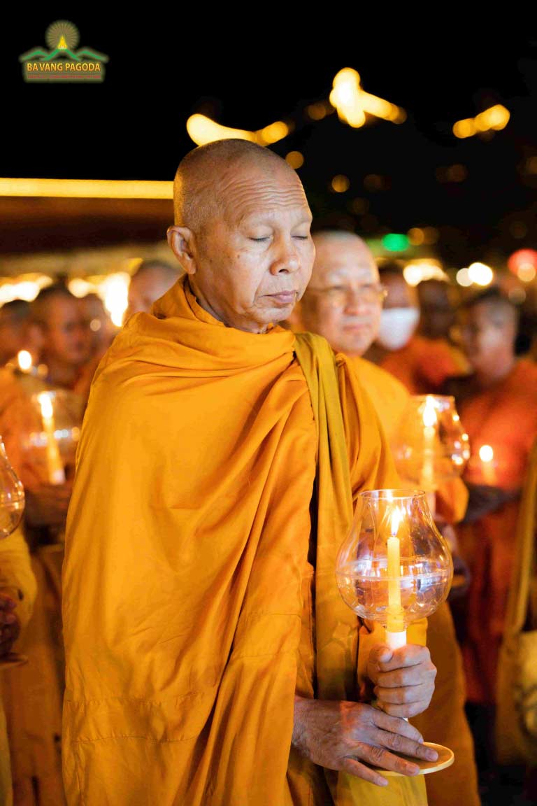 A monastic guest in the Lantern Parade to offer to the Buddha.