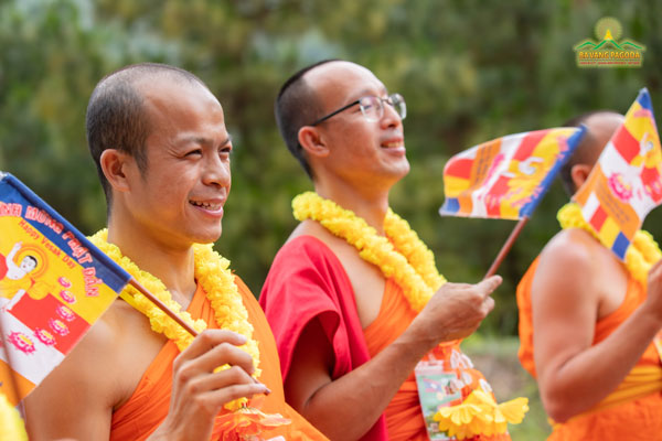 A Thai monk happily waving the Buddist flag in VESAK celebration 2022 at Ba Vang Pagoda