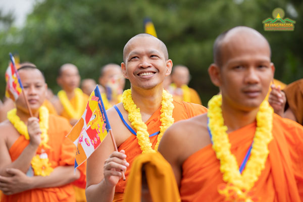 A Thai monk happily waving the Buddist flag in VESAK celebration 2022 at Ba Vang Pagoda