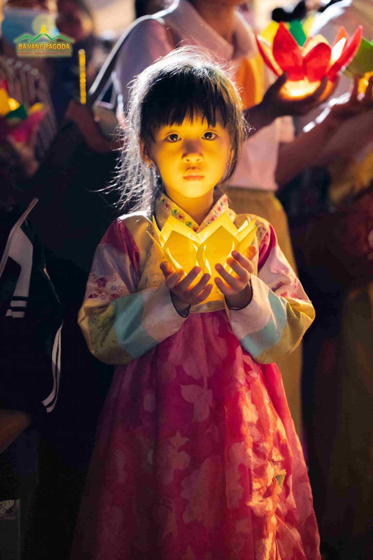 Little Buddhists in traditional Korean Hanbok, with lotus lamps in hand to make offerings to the Buddha.