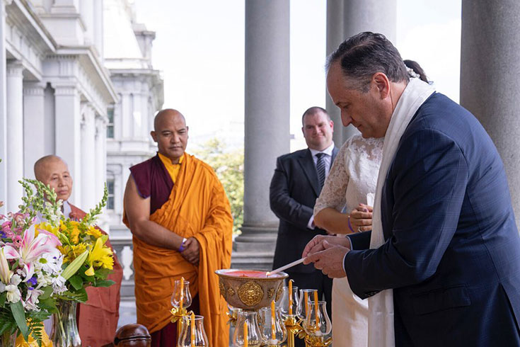 Mr. Douglass Emhoff lights a candle to pay homage to the Buddha.